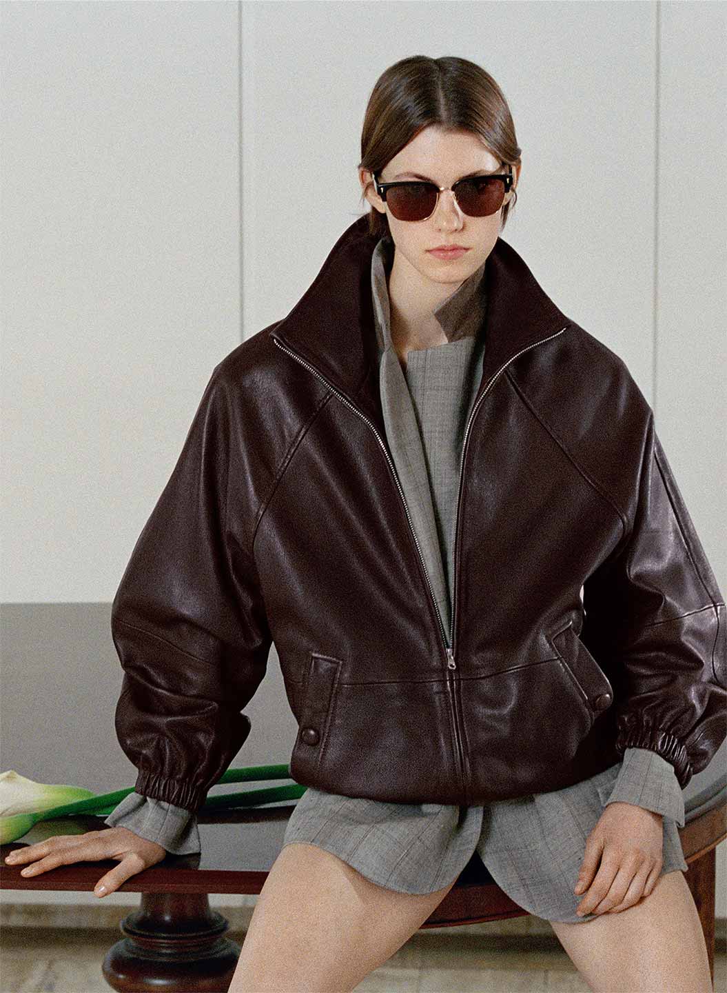 Dana Smith wearing an oversized zip-up leather jacket from Sandro SS26, contrasted with geometric concrete backdrops.